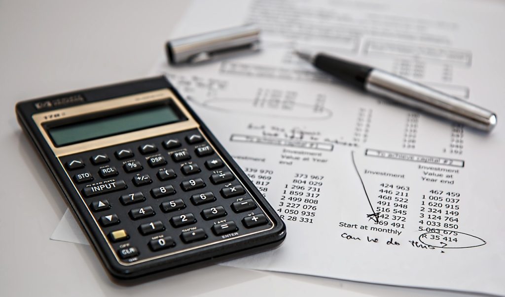 Calculatrice et documents avec stylo évoquant un contrat