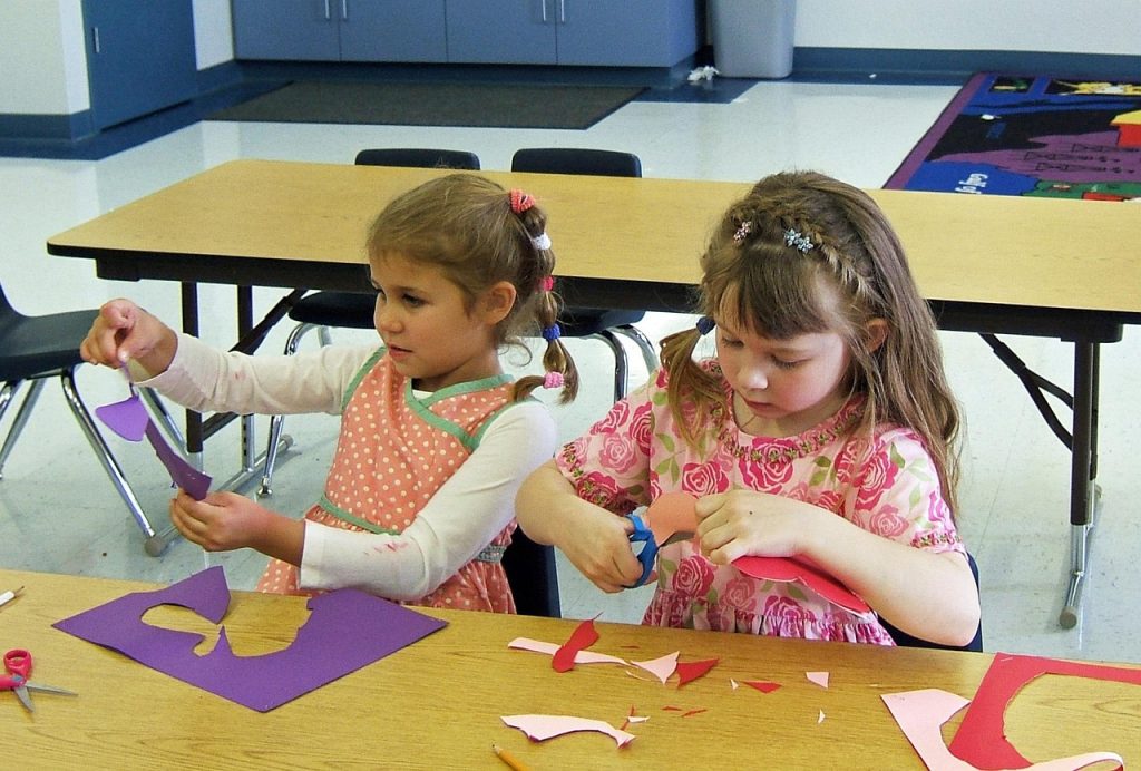 Deux fillettes font une activité manuelle en classe