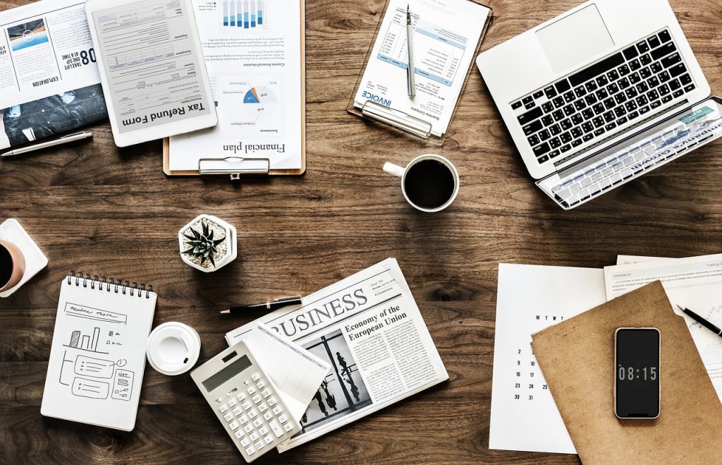 Bureau avec journal, ordinateur portable et téléphone pour gérer ses finances