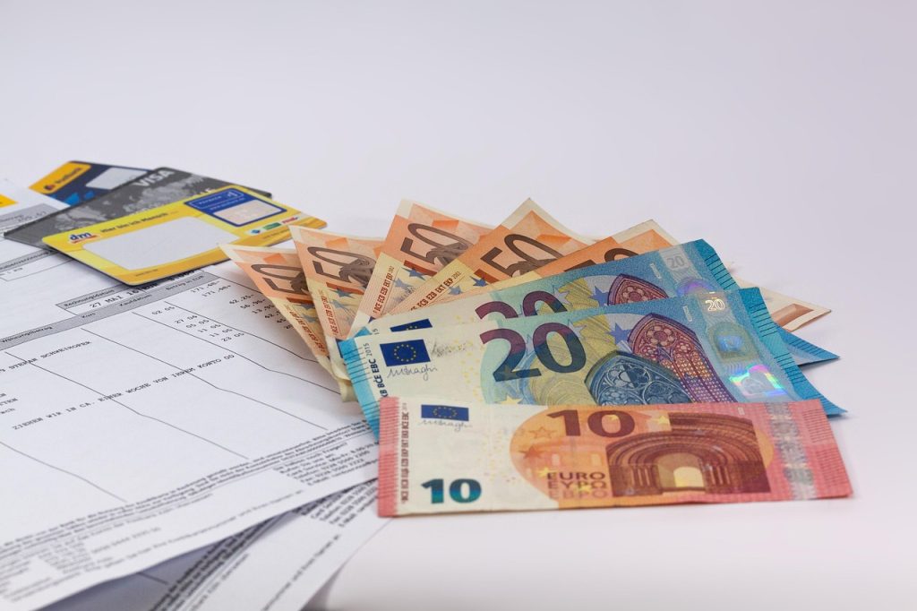 Billets en euros posés sur des factures