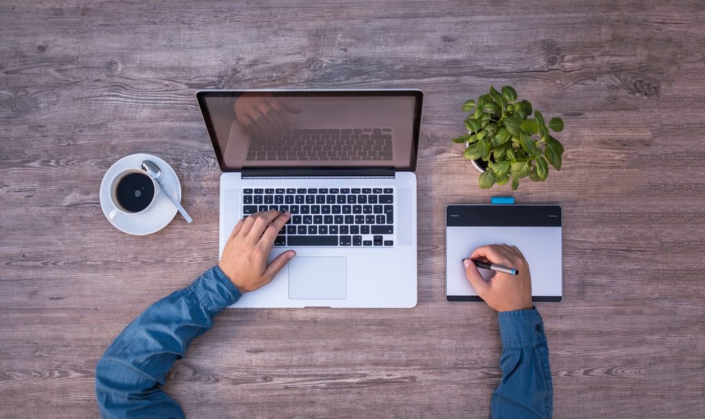 Vue de dessus d'un bureau avec ordinateur portable et personnes au travail