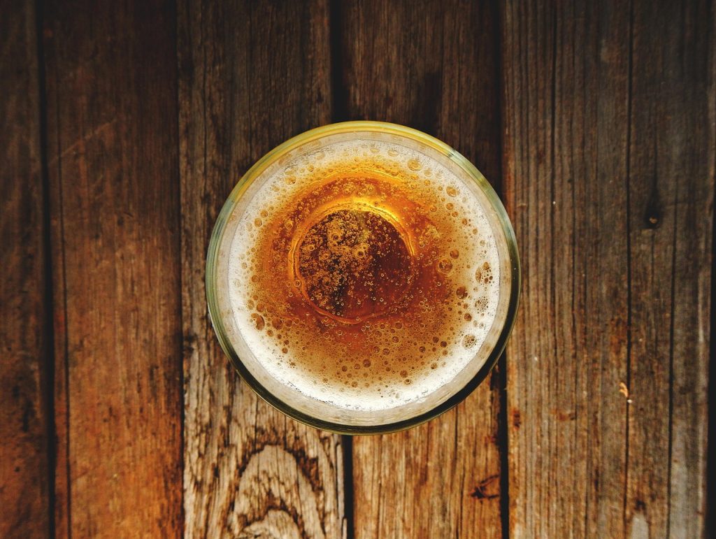 Verre de bière vu de dessus posé sur une table en bois
