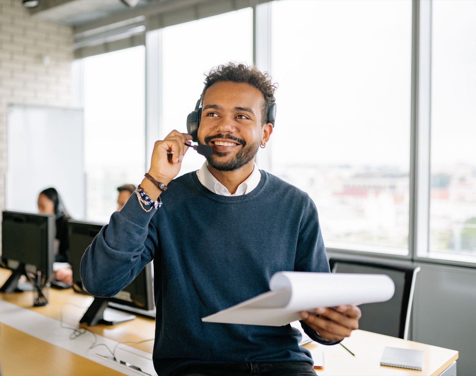 employée répondant au téléphone avec un casque et un carnet de notes