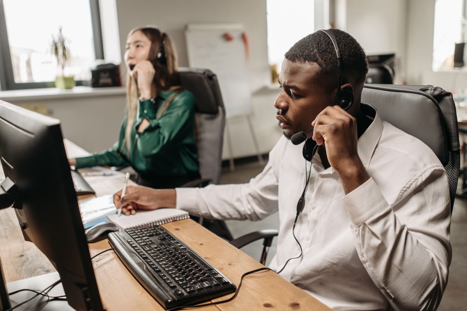 Salarié d'une petite entreprise répondant au téléphone à son bureau