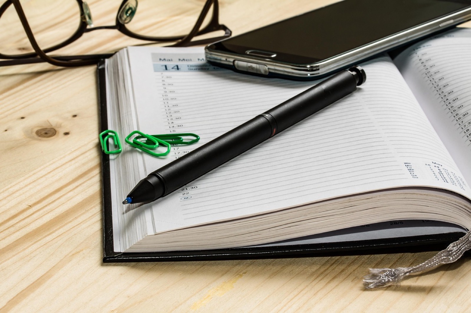 Ordinateur portable ouvert sur un agenda de rendez-vous dans un bureau