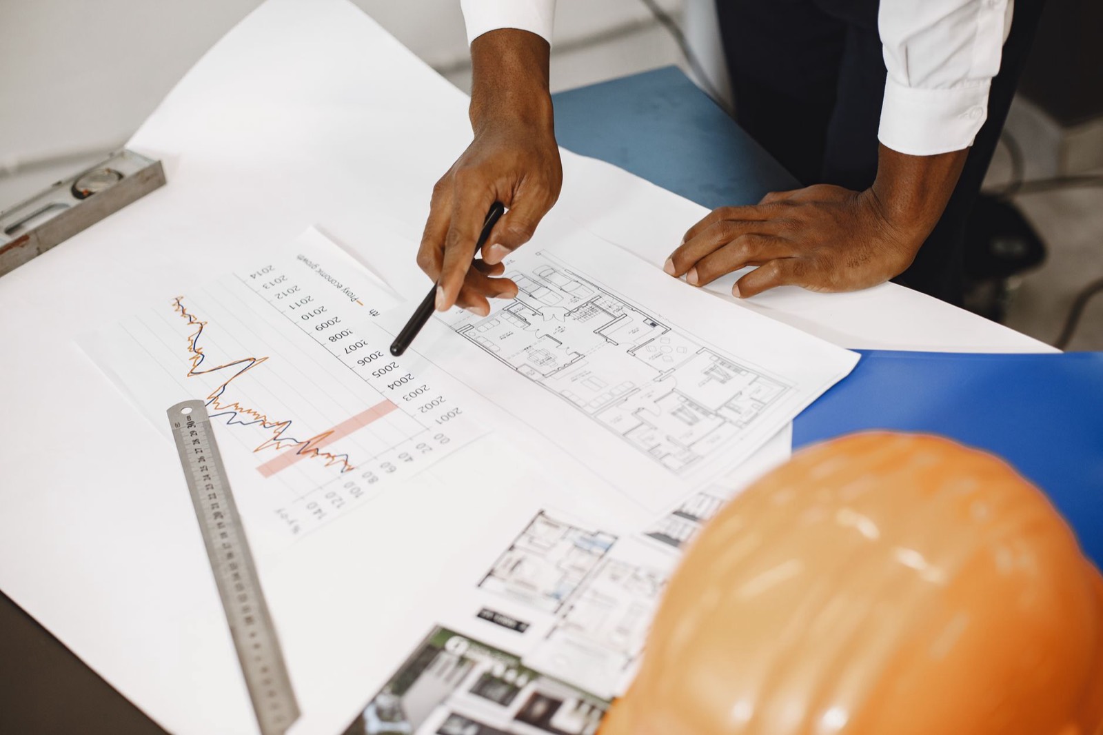 Plan d'appartement posé sur un bureau avec des documents