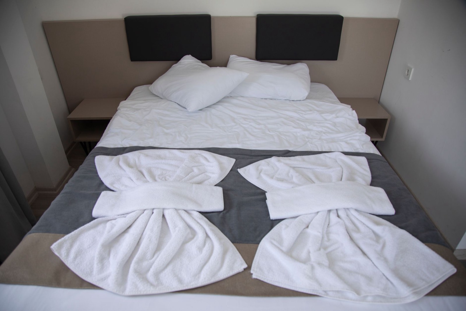 Draps et serviettes pliés sur un lit préparé pour une location saisonnière