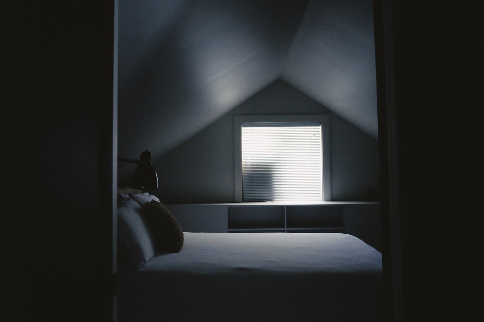 Chambre de petit appartement séparée du séjour par une porte